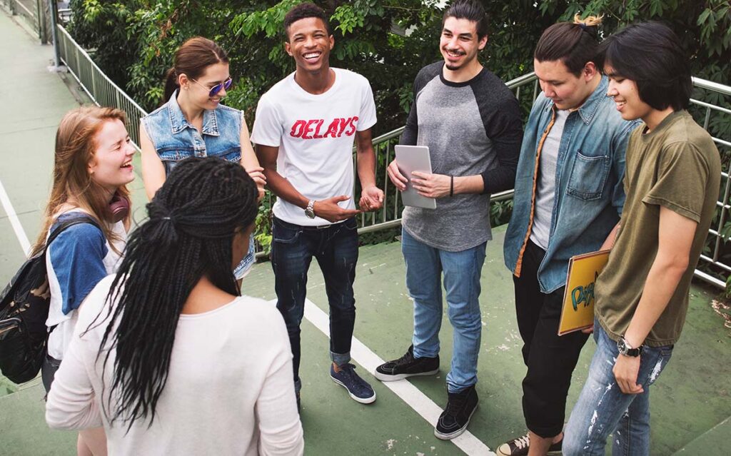 a group of young people stand outside talking and smiling at ADHD treatment