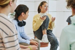 a teen talks to a group during a dialectical behavior therapy program