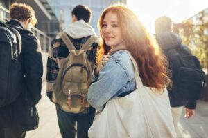 a teen smiles at the camera outside in a group during Adolescent Intensive Outpatient Program