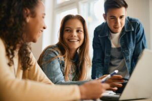 three teens look at a computer during Adolescent Treatment Programs