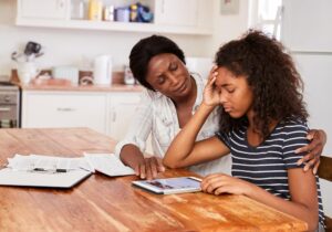 a young person and a parent look concerned while looking at a tablet for anxiety help