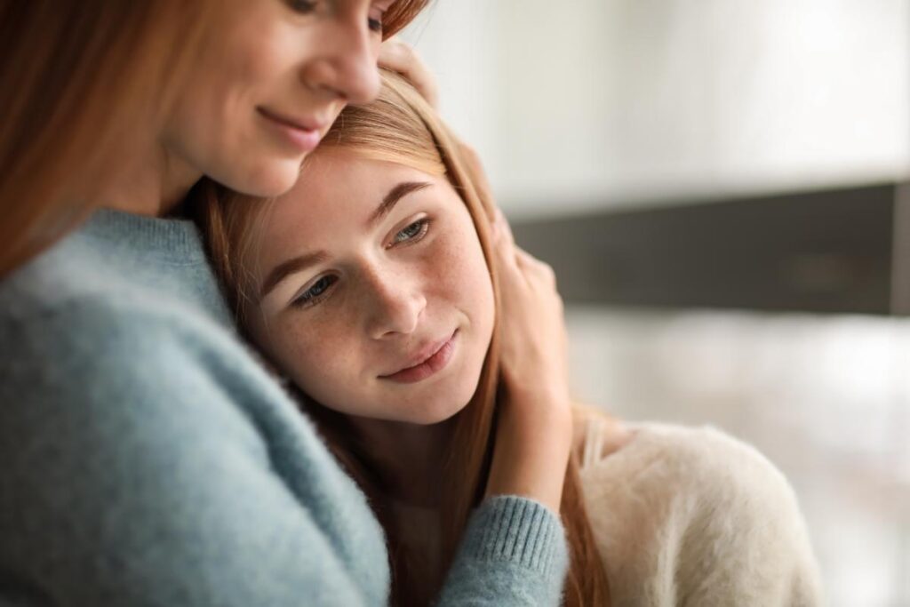 a young person leans on their parent in a hug during anxiety help