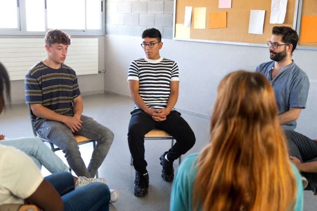 people sit in chairs and talk during trauma treatment