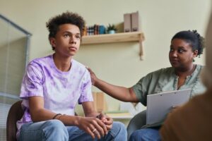 a young person is comforted in a group therapy session for trauma