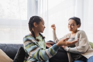 two people sit in a chair and talk about an aftercare program