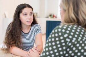 a young person talks to an adult during a psychotherapy program