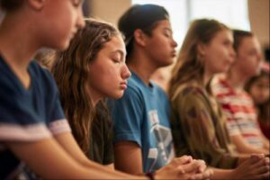 a group of teens meditate during holistic therapy