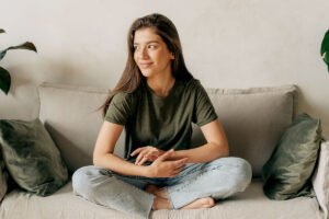 adolescent sitting on couch smiling after receiving treatment and learning signs of adhd in teens