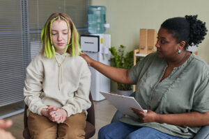 counselor comforting troubled teen in an iop for teens